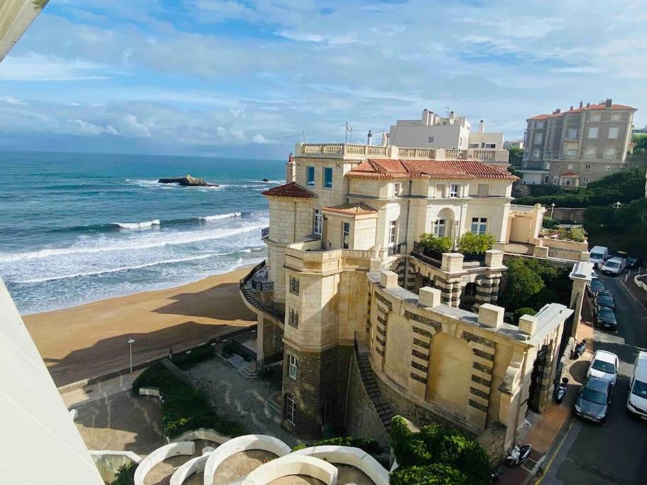 a building on the beach next to the ocean at Studio front de mer Biarritz - Spa & Thalasso in Biarritz