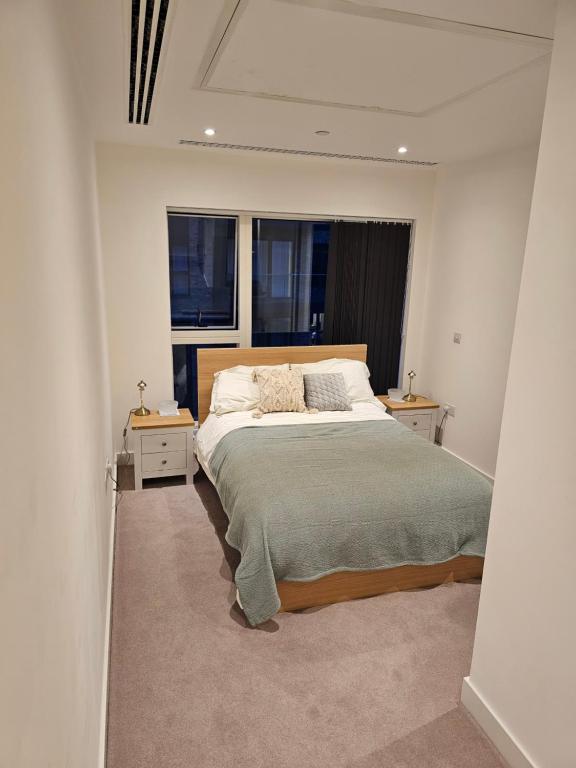 a bedroom with a large bed and two windows at Santina Apartments in Croydon