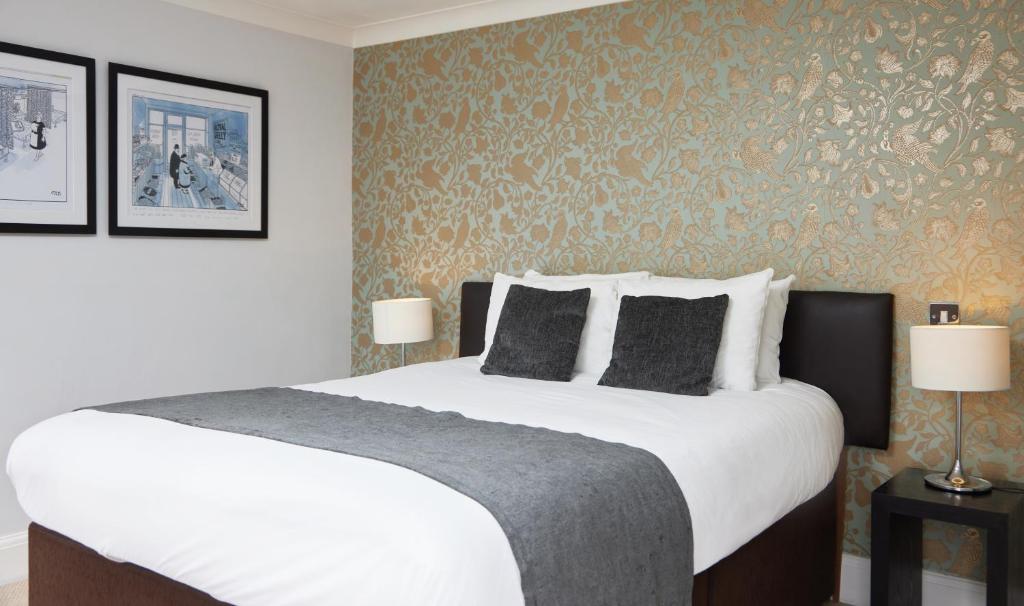 um quarto com uma grande cama branca e 2 candeeiros em Chequers Inn by Greene King Inns em Maresfield