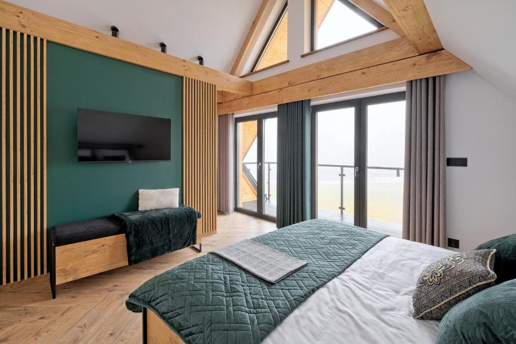 a bedroom with a large bed and a tv at Domek Panorama z Jacuzzi in Ząb