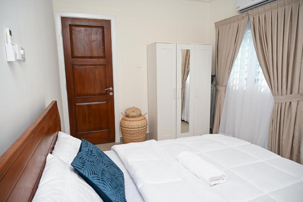 Schlafzimmer mit einem Bett und einer Holztür in der Unterkunft Lokko Serene in Accra