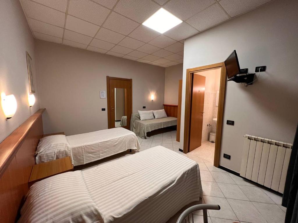 een hotelkamer met 2 bedden en een slaapkamer bij Shelter Affittacamere in Genua