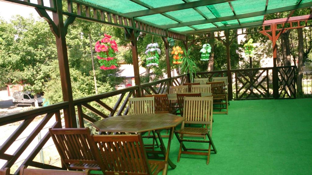 a patio with a table and chairs on a green floor at Hotel Hermes in Eforie Nord