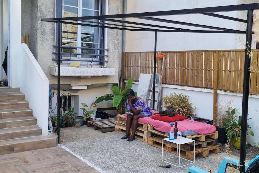 een man op een bed op een patio bij House with outbuilding near Stade de France in Épinay-sur-Seine
