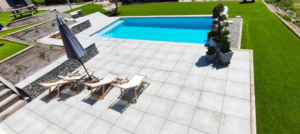- une vue sur la piscine avec des chaises et un parasol dans l'établissement chambre 2 vue lac av piscine, à Prunières