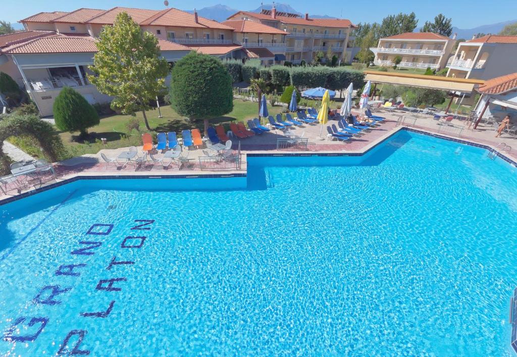 an overhead view of a large swimming pool with chairs and umbrellas at Grand Platon Hotel in Olympic Beach