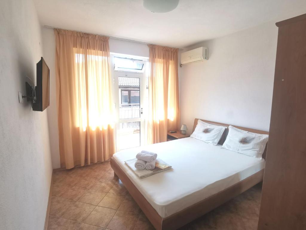 1 dormitorio con cama blanca y ventana en Dream House, en Tsarevo