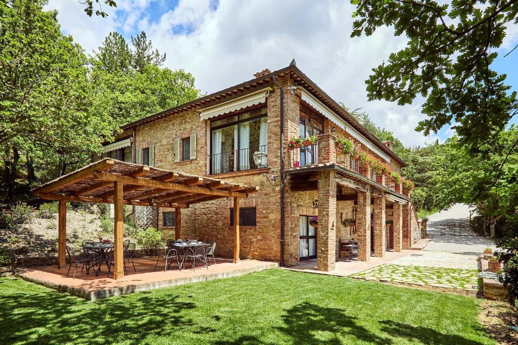 an exterior view of a house with a lawn at Podere Lamberto in Montepulciano