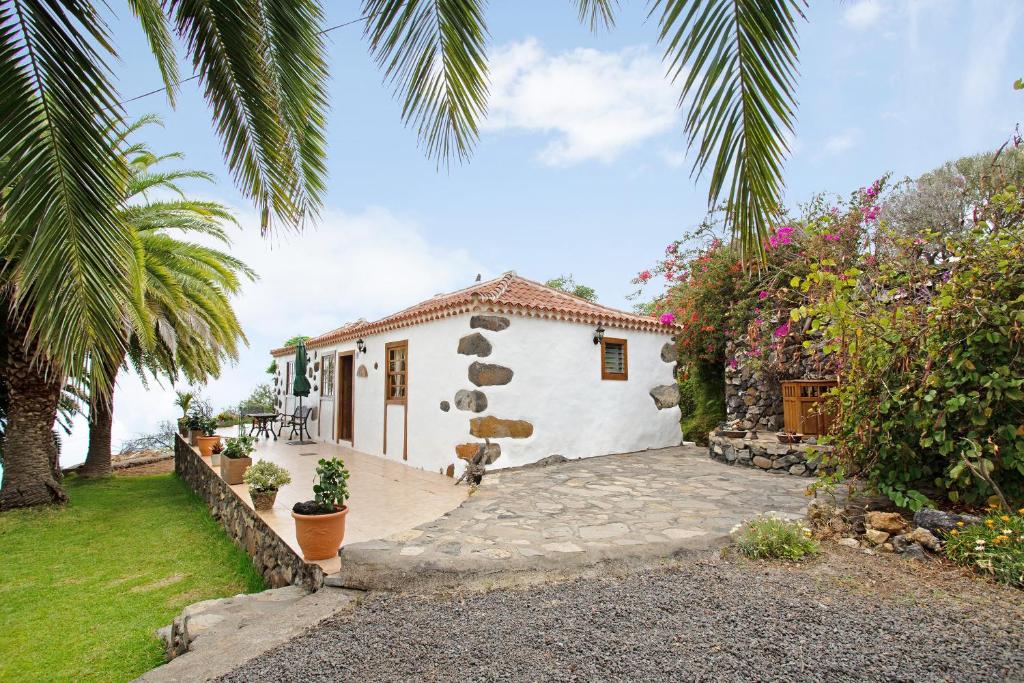 Biały dom z palmą i ogródkiem w obiekcie Casa Rural Ciso w mieście Tijarafe