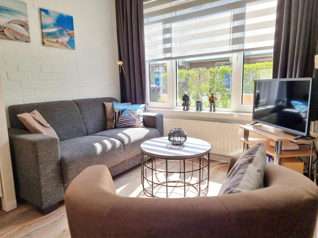 a living room with a couch and a tv at Sfeervolle vakantiewoning Domburg DO15 in Domburg