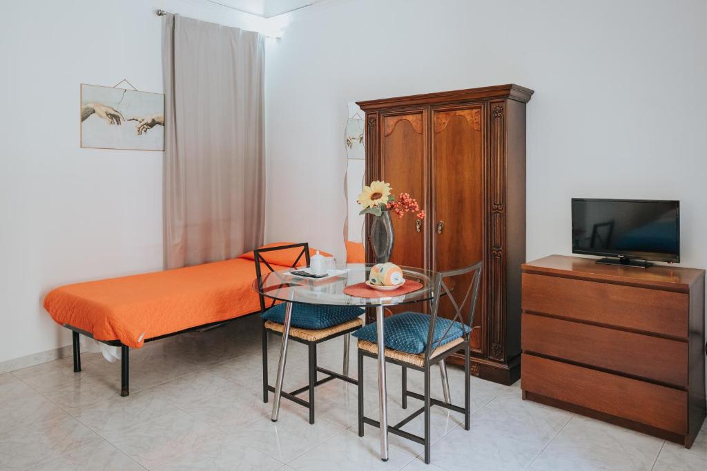 sypialnia z łóżkiem, stołem i telewizorem w obiekcie B&B Nuovo Reale - CENTRO STORICO w mieście Lecce