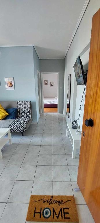 a living room with a welcome home rug on the floor at Sea flight in Preveza
