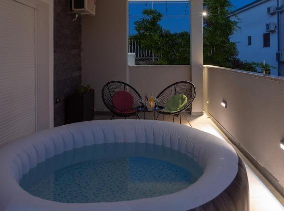 a hot tub on a balcony with a table and chairs at Apartments Pasalic in Kaštela