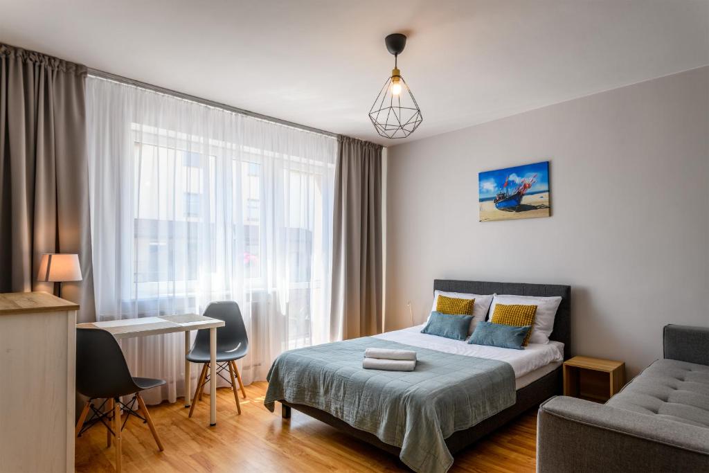 弗瓦迪斯瓦沃沃的住宿－Złoty Piach，一间卧室配有一张床、一张沙发和一张桌子