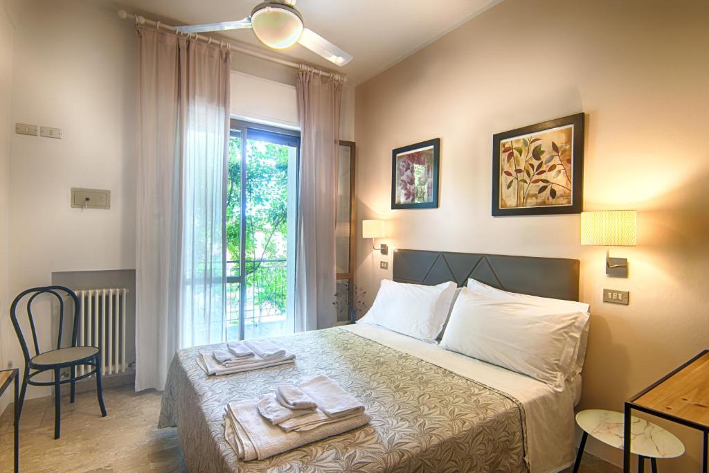 sypialnia z łóżkiem i dwoma ręcznikami na nim w obiekcie Albergo Villa Lucia w mieście Bellaria-Igea Marina