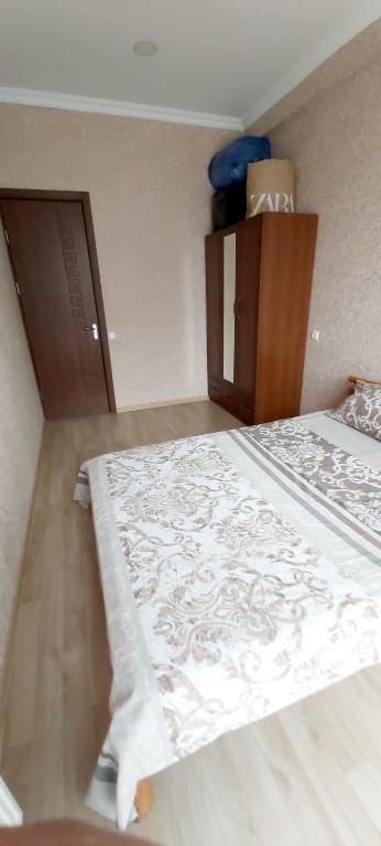 a bedroom with a bed with a white blanket on it at Balavari Samgori Guest House in Tbilisi City