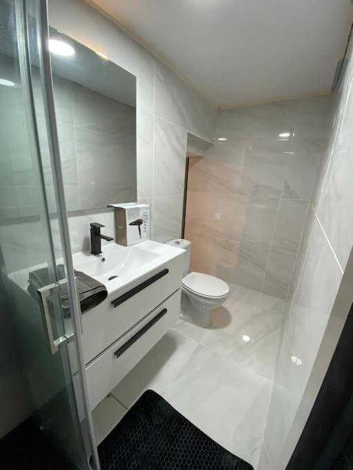 a white bathroom with a toilet and a sink at Loft, muy cerca de playa y castillo Tamarit in Tarragona