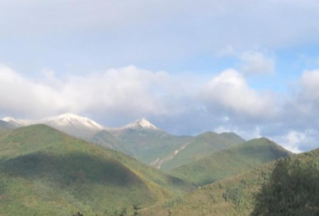 a view of a mountain range with snow capped mountains at Ferme-auberge le cochon du Madres in Escouloubre