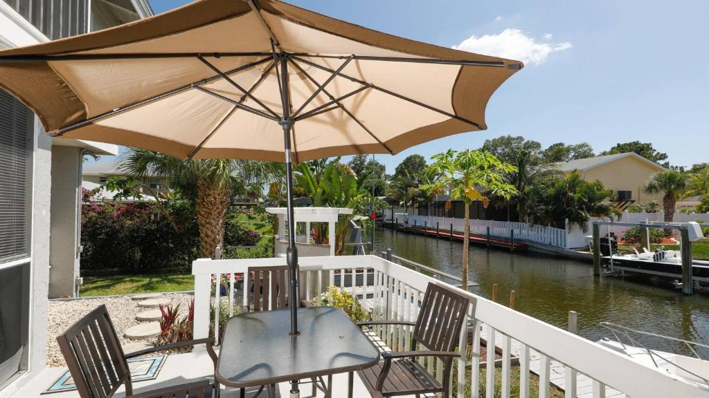 a table with an umbrella and chairs next to a river at 9141 Lake #102 in Englewood