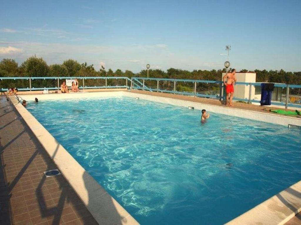 a large swimming pool with people in the water at Nice Apartment only 150 metres from the Beach by Beahost Rentals in Bibione