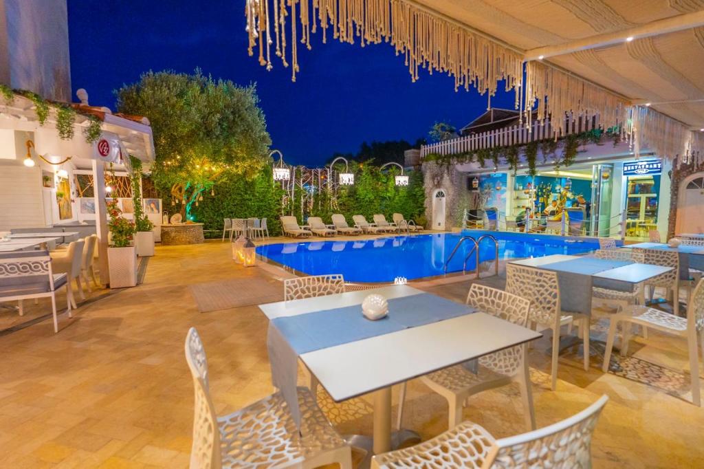 un patio con mesas y sillas y una piscina en Hotel Valz, en Velipojë