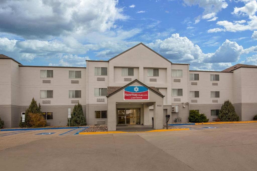 a large white building with a sign on it at SureStay Plus Hotel by Best Western Minot in Minot