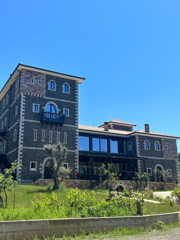 a large brick building with a garden in front of it at N’Kanu in Rrëshen