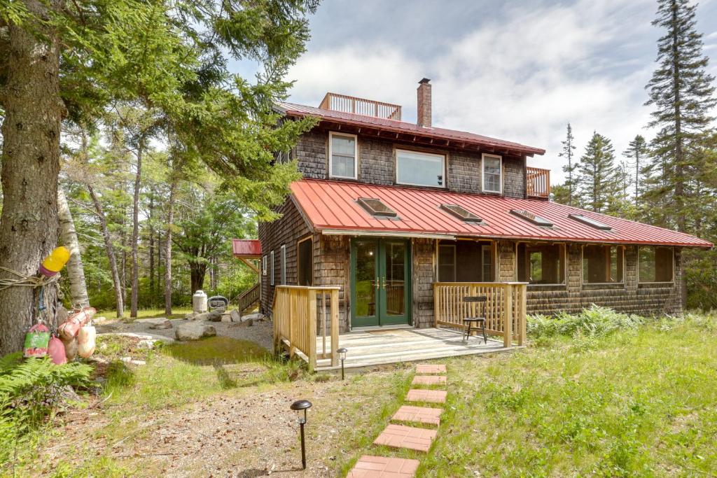 a house with a red roof and a deck at Enchanting Retreat in Prospect Harbor in Prospect Harbor