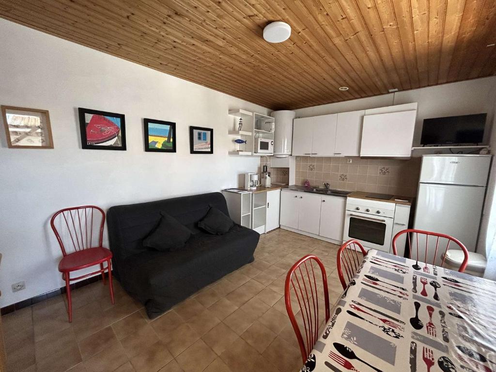 un salon avec un canapé, une table et des chaises dans l'établissement Maison cosy 2 pièces, plage et centre à 300m, terrasse, TV, animaux permis - La Guérinière - FR-1-224B-192, à La Guérinière