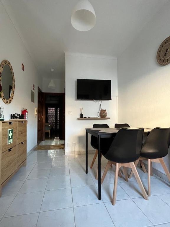 ein Esszimmer mit einem Tisch und Stühlen sowie einem TV in der Unterkunft Casas da Margarida in Vila Nova de Foz Côa