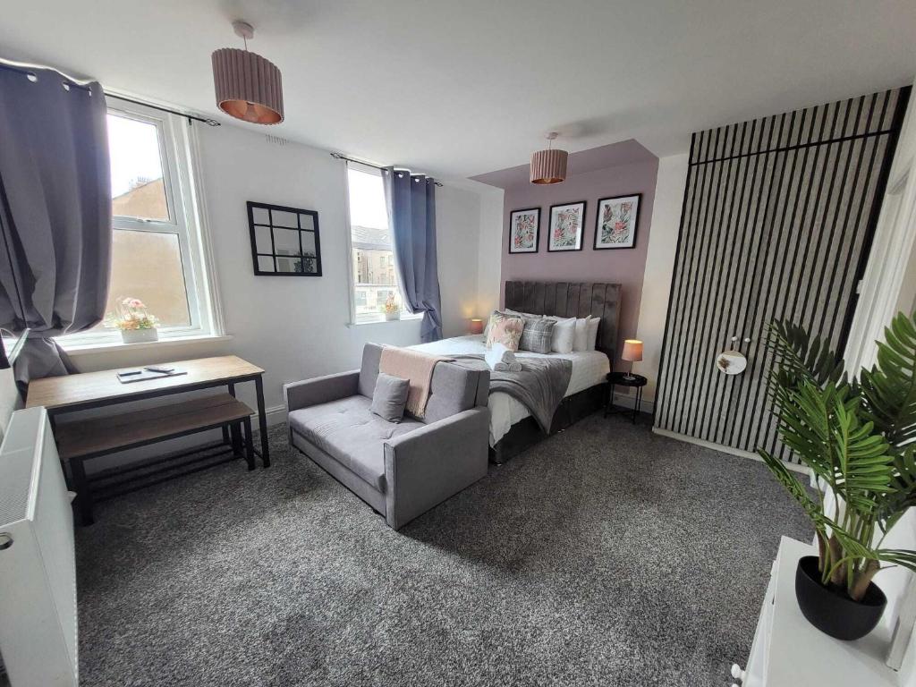 1 dormitorio con cama, sofá y mesa en Blackpool Abode - Sunny Suite Apartment, en Blackpool
