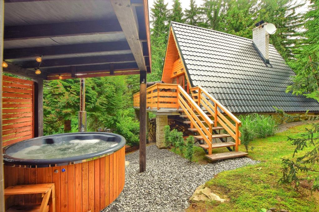 a hot tub in a yard next to a house at Górska Pasja Istebna in Istebna