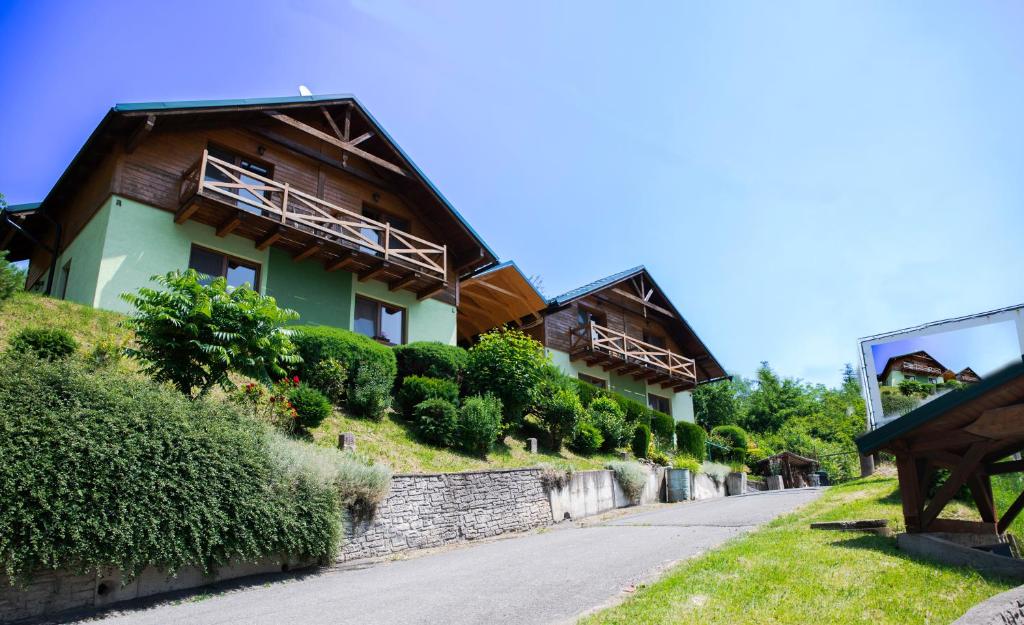 une maison sur une colline avec un banc à côté de celle-ci dans l'établissement Apartmány Alma, à Vyhne