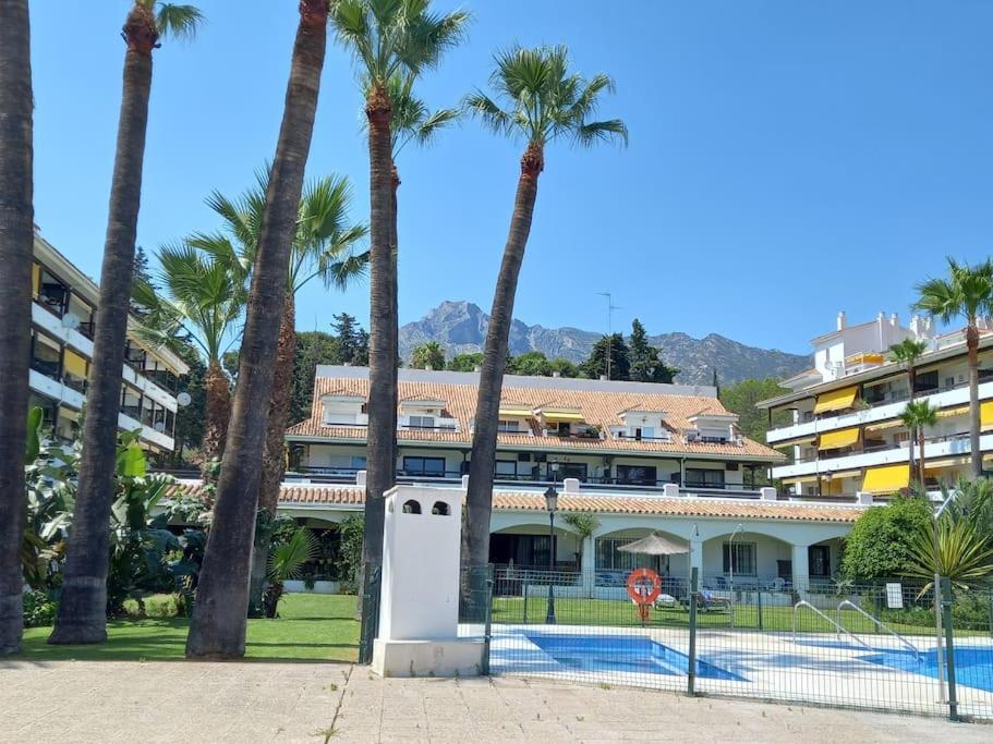 un edificio con palmeras frente a una piscina en Vacaciones en Marbella, en Marbella