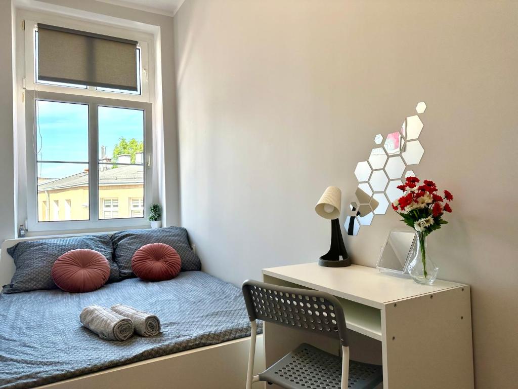 a room with a bed with a desk and a window at MMRent Wave Room in Gdańsk