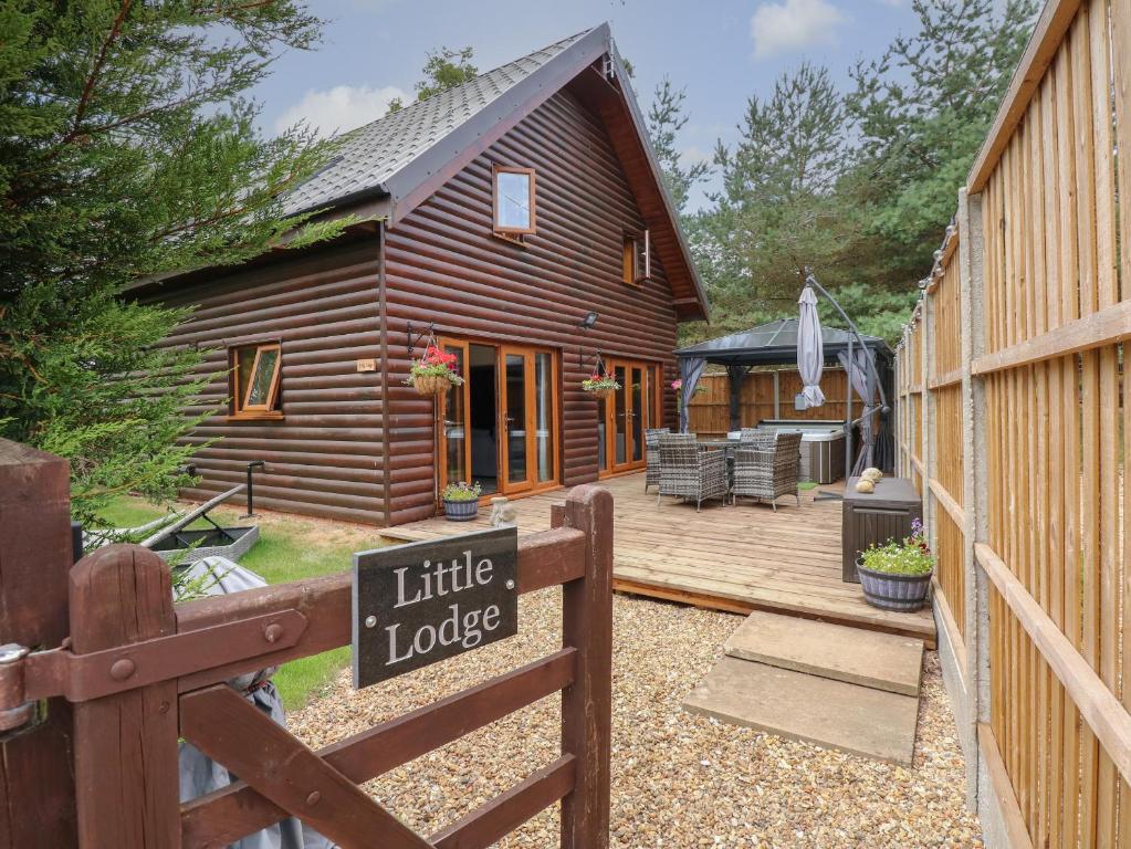 una cabaña de madera con una valla de madera y un pequeño lodge en Little Lodge, en Kings Lynn