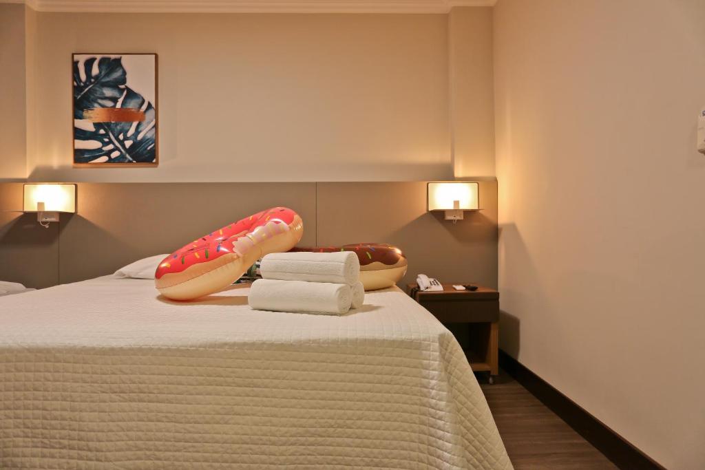 Una habitación de hotel con una cama con toallas. en Sandri City Hotel, en Balneário Camboriú