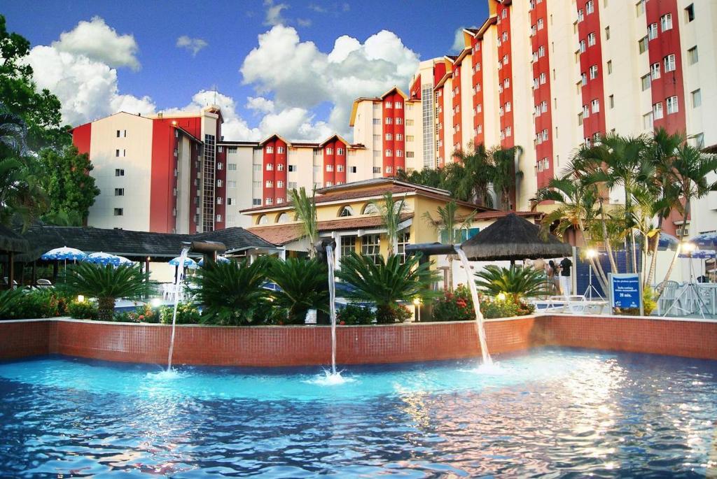 a large swimming pool with fountains in front of buildings at HotSprings Hotel in Caldas Novas