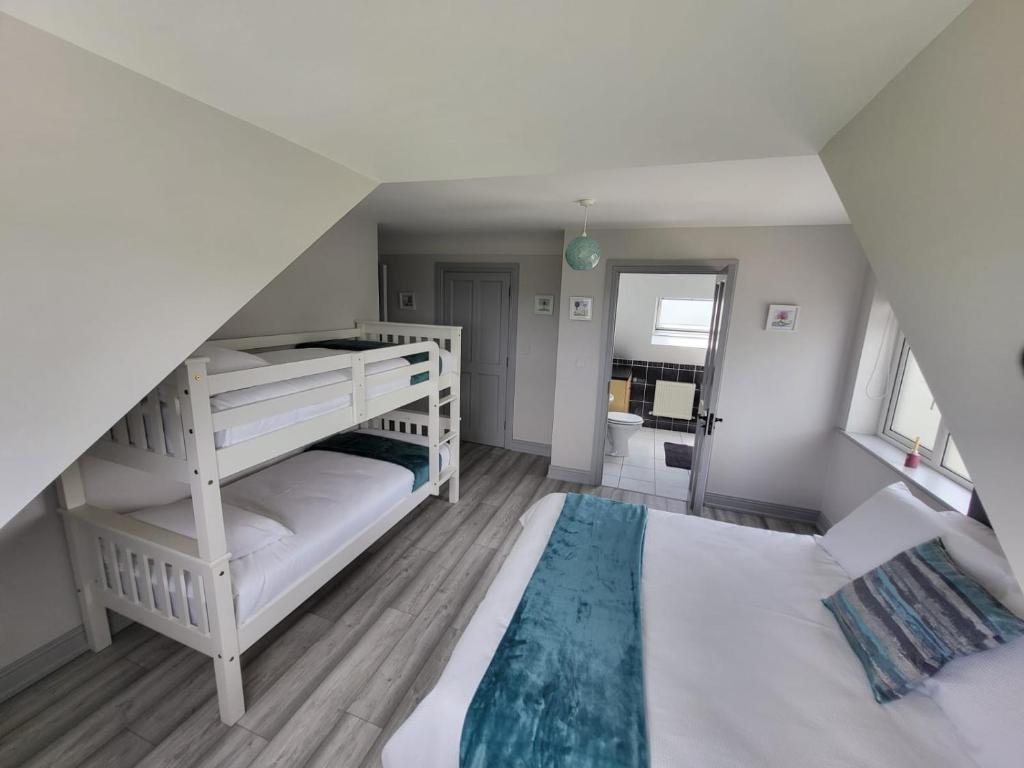 a bedroom with two bunk beds and a staircase at Curragh View in Killybegs