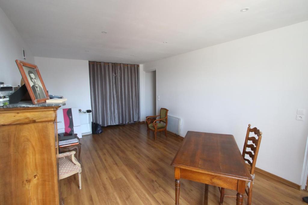 a living room with a wooden table and chairs at Super appartement avec belle luminosité en plein centre ville de Sisteron in Sisteron