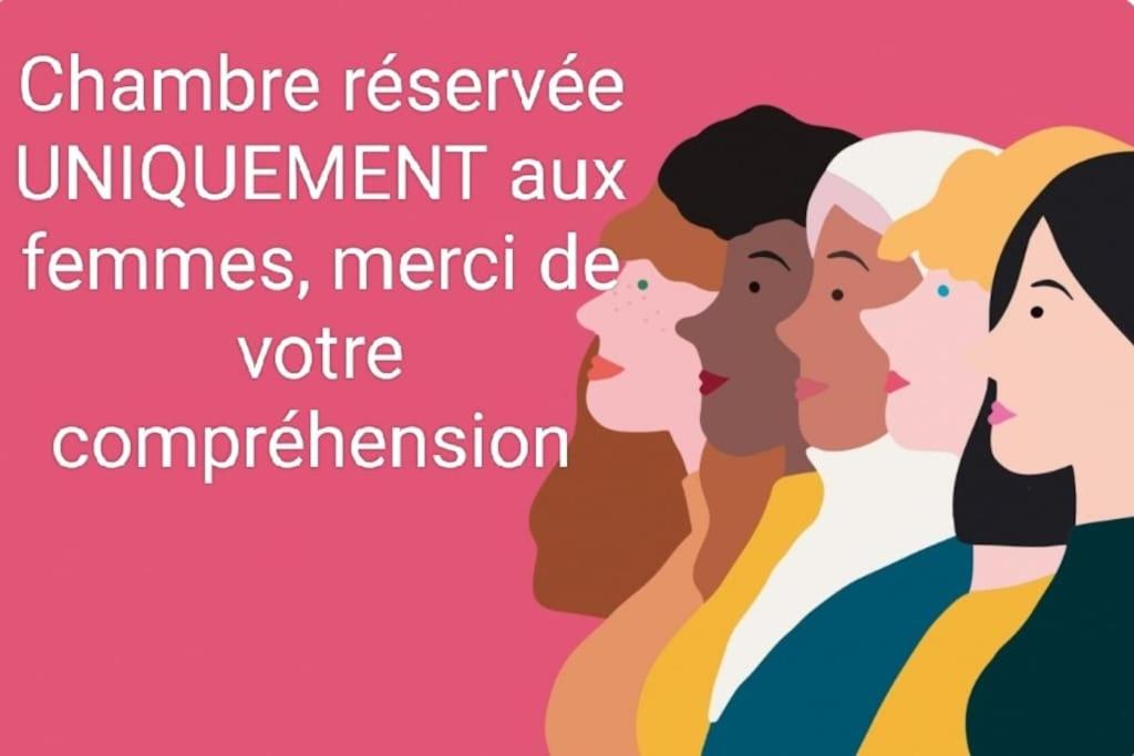 a group of women standing in front of a pink background at La Violette ONLY WOMEN femmes uniquement in Vénissieux