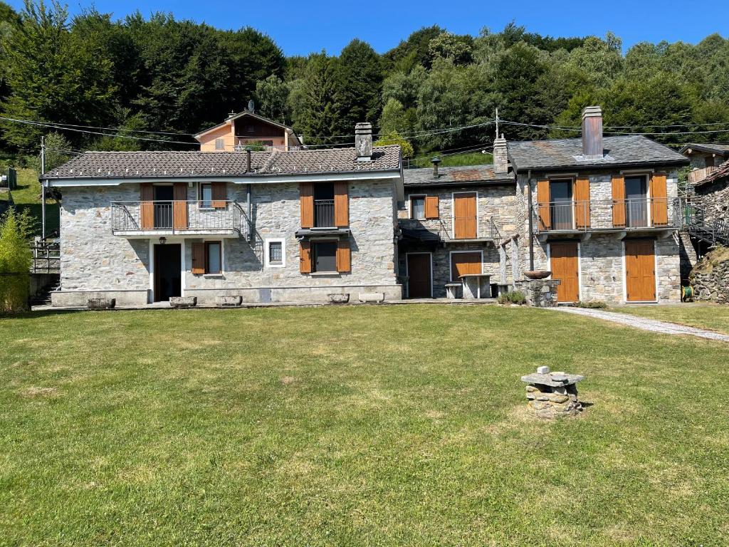 an old stone house with a grass yard at Villa Primula in Monti di Pino