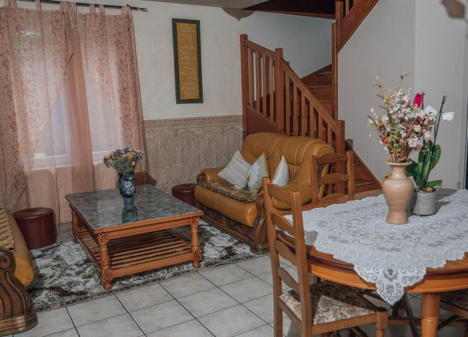 a living room with a table and a chair at La Violette ONLY WOMEN femmes uniquement in Vénissieux