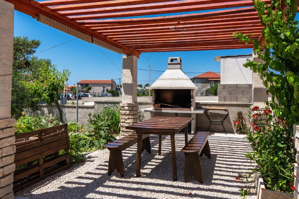 a patio with a table and a pizza oven at Apartment Olea in Vir