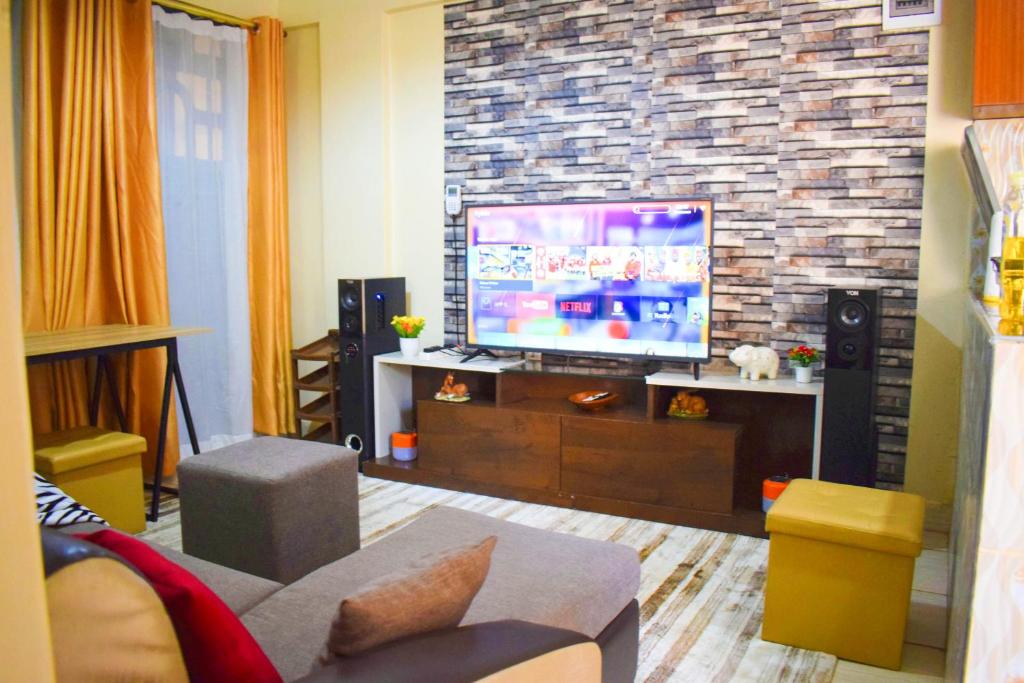a living room with a tv and a couch at Casabella Apartment - Pristine Homes,Tom Mboya in Kisumu