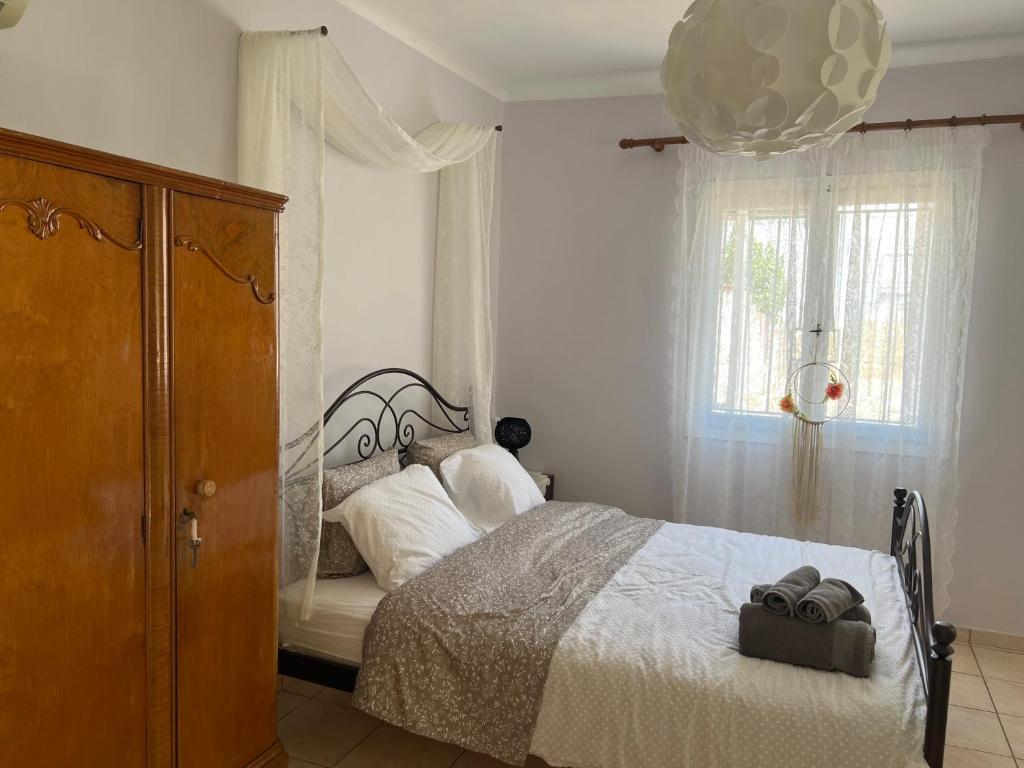 1 dormitorio con cama y ventana en Yiayia Katina’s House en Korinthos