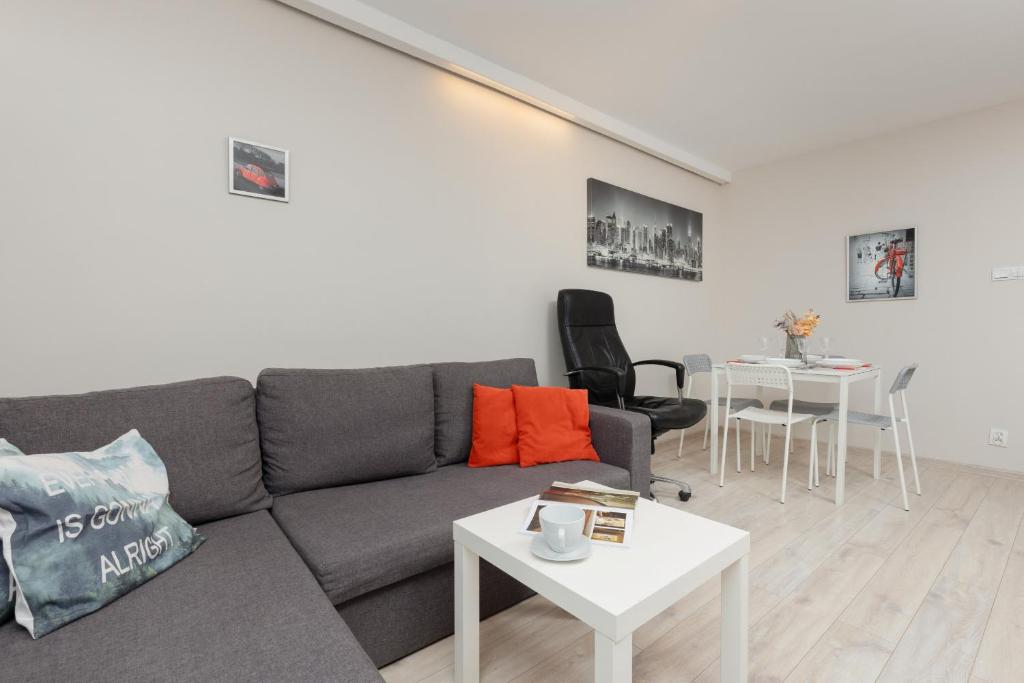 uma sala de estar com um sofá cinzento e uma mesa em Pet-Friendly Apartment in City Center by Renters em Varósvia