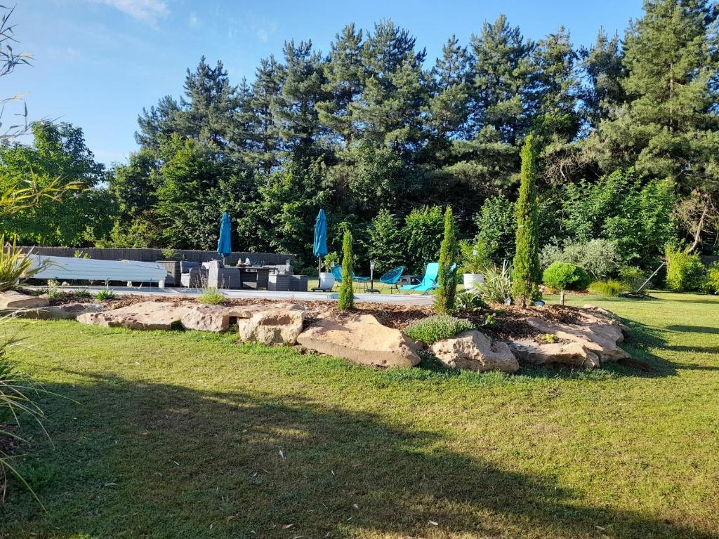 un jardin avec des arbres et des rochers dans une cour dans l'établissement CHAMBRE CHAMPÊTRE, à Angrie