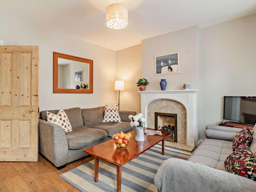 a living room with a couch and a fireplace at Harbour Walk in Brightlingsea