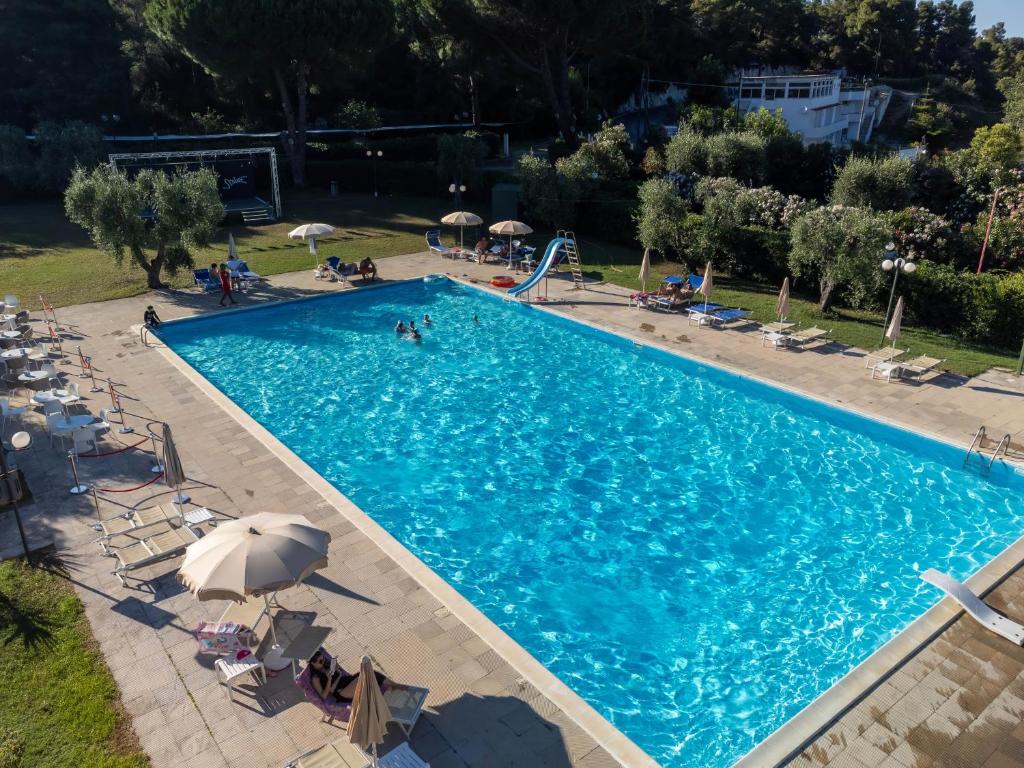 an overhead view of a swimming pool with chairs and umbrellas at Hotel Mira in Peschici